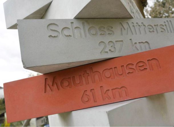 Stele aus Betonprismen mit eingravierten Schriftzügen der Ortschaften und Entfernungen von BK BetonDESIGN