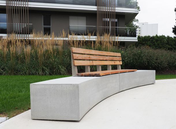 Geschwungener Betonsitzblock mit Holzauflage und Rückenlehne