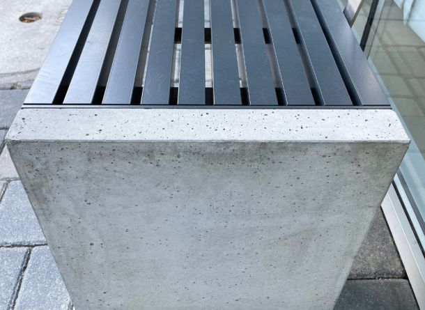 Detailansicht der Sitzbank von den Betonstützen mit der Aluminiumsitzfläche