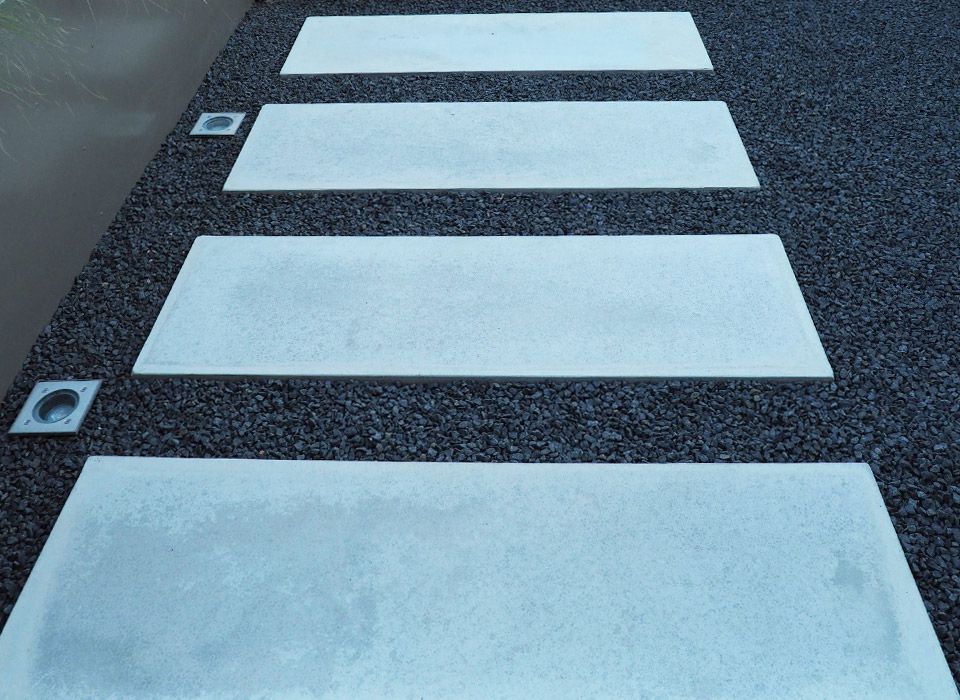 Detailansicht der Gehwegplatten aus Beton in Zementgrau mit schwarzem Zierkies