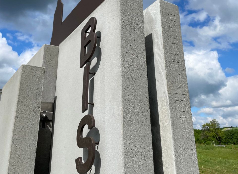 Gestaltungselement aus Beton mit Schriftzug aus Stahl in Rostoptik 