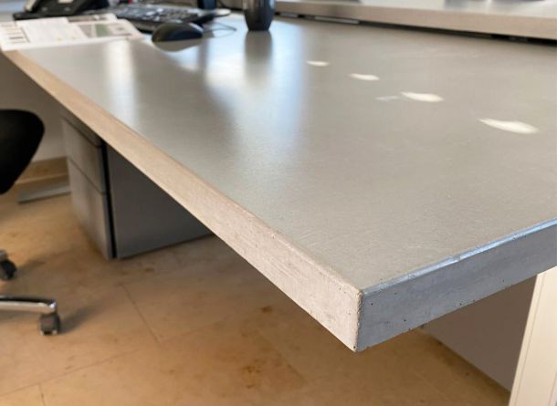 Detailansicht der Schreibtischplatte aus Beton in Blaugrau mit dezenter Microfase und schalrein glatter Oberfläche mit Beschichtung